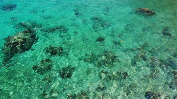 Calm sea water near stones. Peaceful blue sea water and gray boulders in perfect place for snorkeling on Koh Tao Island on sunny day in Thailand. Natural background texture