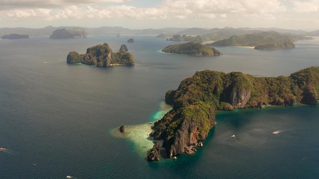 Cove with lagoons and the tropical islands, aerial view. Seascape with tropical rocky islands, ocean blue water. islands and mountains covered with tropical forest. El nido, Philippines, Palawan. Tropical Mountain Range