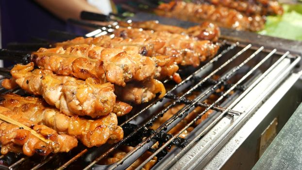 Meat kebabs frying on street. Set of yummy meat kebabs grilling on grating in traditional street cafe in Thailand