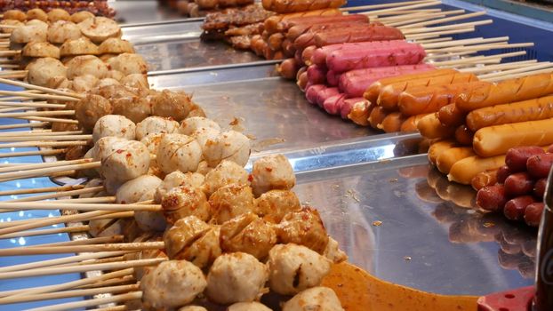 Traditional Asian night street food market in Thailand. Barbecue meatballs and other exotic delicious snacks for sail. Ready to eat food.