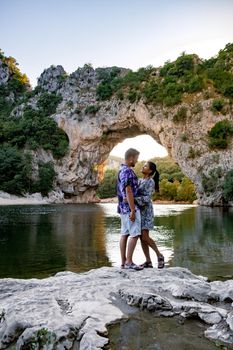 couple men and woman visiting The famous natural bridge of Pont d'Arc in Ardeche department in France Ardeche. Europe Rhone Alpes