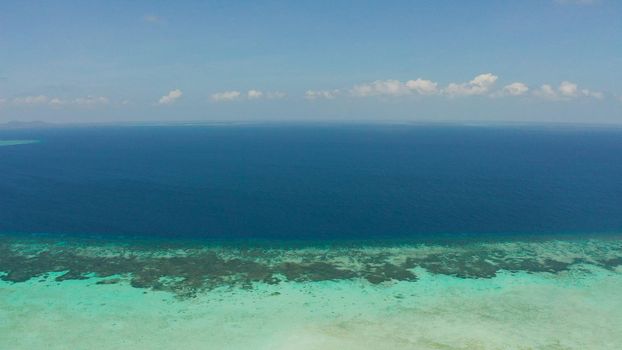 Tropical coral atoll with turquoise water against the sky with clouds top view. Summer and travel vacation concept. Balabac, Palawan, Philippines