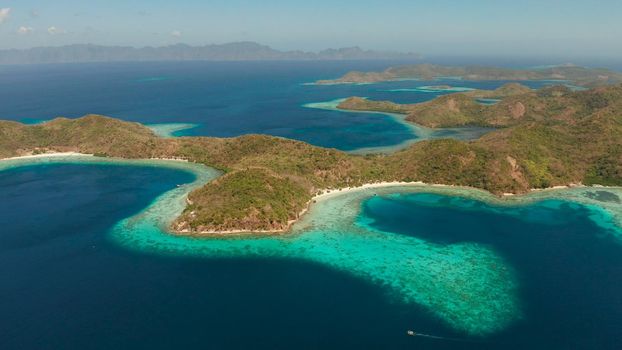 aerial view tropical islands with blue lagoon, coral reef and sandy beach. Palawan, Philippines. Islands of the Malayan archipelago with turquoise lagoons.