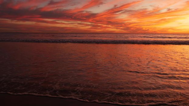 California summertime beach aesthetic, golden sunset. Vivid dramatic clouds over pacific ocean waves. Santa Monica popular resort, Los Angeles CA USA. Atmospheric moody purple evening sundown in LA.