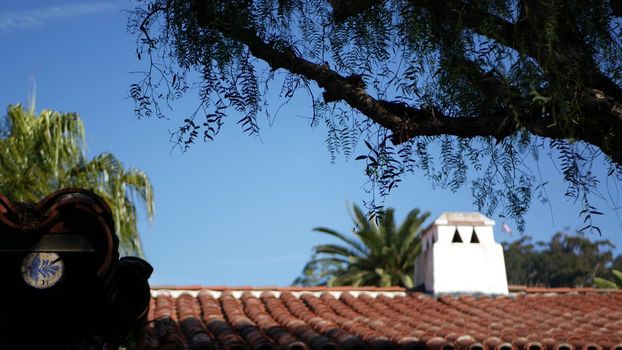 Mexican colonial style suburban, hispanic house exterior, green lush garden, San Diego, California USA. Mediterranean terracotta ceramic clay tile on roof. Rustic spanish tiled rooftop. Rural details.