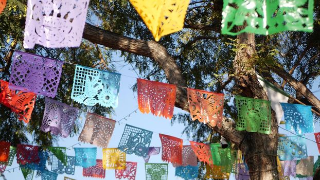 Colorful mexican perforated papel picado banner, festival colourful paper garland. Multi colored hispanic folk carved tissue flags, holiday or carnival. Authentic fiesta decoration in Latin America.