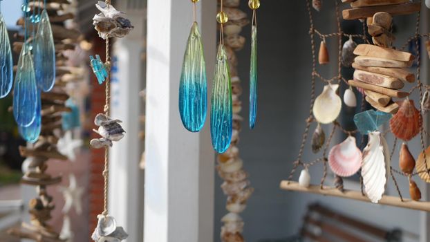 Nautical style hanging seashells decoration, beachfront blue wooden holiday home, pacific coast, California USA. Marine pastel interior decor of beach house in breeze. Summertime sea wind aesthetic.