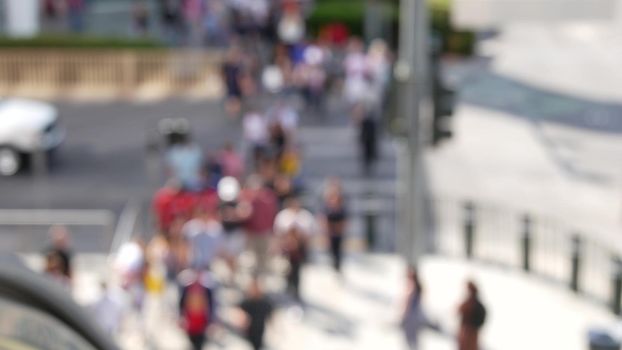 Defocused crowd of people, road intersection crosswalk on The Strip of Las Vegas, USA. Anonymous blurred pedestrians on walkway in crowded urban downtown. Unrecognizable american citizens in sin city.