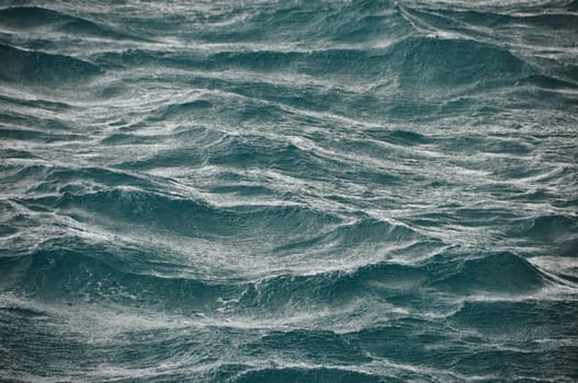 Background of abstract flowing waves of ocean in stormy weather. Rough majestic waves of ocean