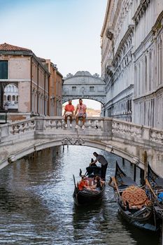 Canals of Venice Italy during summer in Europe,Architecture and landmarks of Venice. Italy Europe, couple men and woman looking at Rialto Bridge Venice Italy June 2020