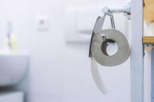Close up of toilet paper roll on chrome hanger