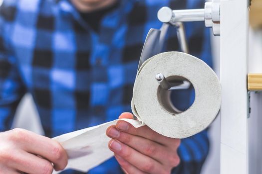 Hand of a male person using toilet paper