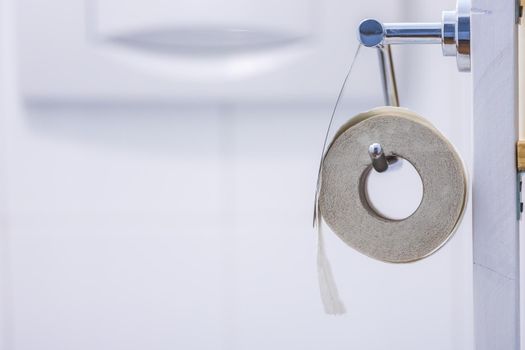 Close up of toilet paper roll on chrome hanger