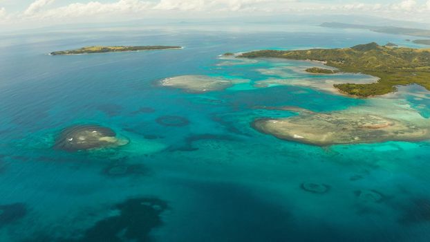Islands are surrounded by an atoll and a coral reef with blue water top view. Bucas grande, Philippines. Summer and travel vacation concept.