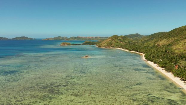 Aerial view tropical island with beach, coral reef and blue lagoon. Busuanga, Palawan, Philippines. Seascape island and clear blue water tropical landscape