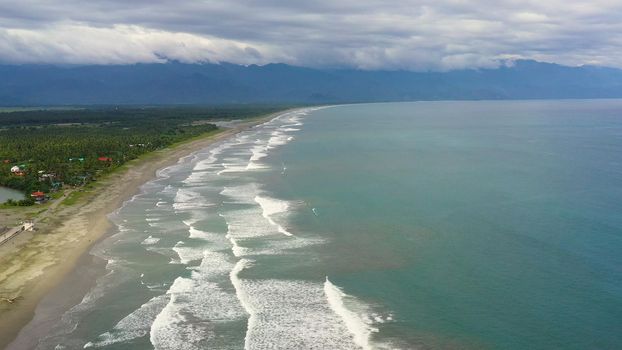 The coast with hotels and tourists, a famous place for surfing in the Philippines, top view. Secret Surf Capital Of The Philippines. Sabang Beach, Baler, Aurora, Philippines.