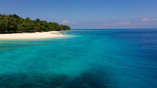 Seascape with a beautiful tropical island, aerial view. Beautiful white sand beach. Mahaba Island, Philippines. Blue sea with turquoise lagoons. Summer and travel vacation concept.