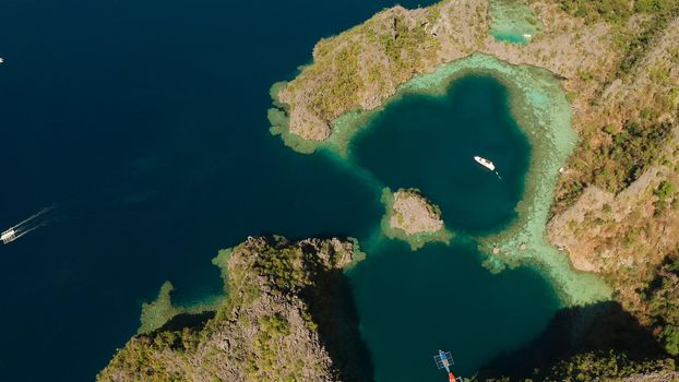 Aerial drone speed boat with tourists in beautiful lagoon. lagoons and coves with blue water among the rocks. Seascape, tropical landscape. Palawan, Philippines, Busuanga