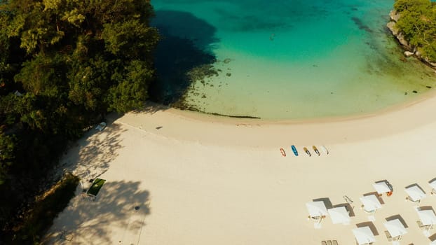 Tropical beach with sun beds near the lagoon with turquoise water Boracay, Philippines, aerial view. Seascape with beach on tropical island. Summer and travel vacation concept.