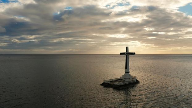 Catholic cross in sunken cemetery in the sea at sunset, aerial view. Sunset at Sunken Cemetery Camiguin Island Philippines.