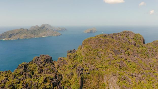 aerial view of bay and the tropical islands. Seascape with tropical rocky islands, ocean blue water. islands and mountains covered with tropical forest. El nido, Philippines, Palawan. Tropical Mountain Range