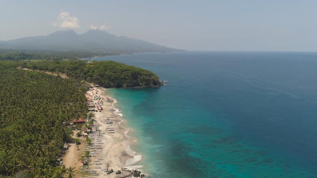 sandy beach with palm trees in tropical resort. aerial seascape sand beach with turquoise water. Seascape, ocean and beautiful beach.Travel concept. Indonesia, Bali
