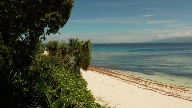 Tropical island in the blue sea with coral reef, top view. Small island with sandy beach. Summer and travel vacation concept, Mantigue island, Philippines, Mindanao