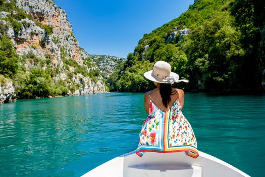 cliffy rocks of Verdon Gorge at lake of Sainte Croix, Provence, France, Provence Alpes Cote d Azur, blue green lake with boats in France Provence. Europe, young woman in peddle boat looking at river