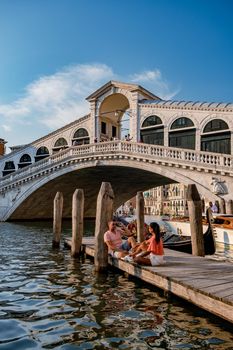 Canals of Venice Italy during summer in Europe,Architecture and landmarks of Venice. Italy Europe, couple men and woman looking at Rialto Bridge Venice Italy June 2020
