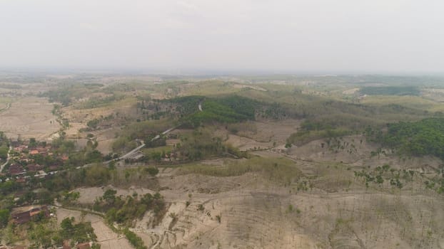 agricultural land in rural areas with farmlands, fields with crops, trees in arid hilly terrain. aerial view growing crops in asia in hilly areas Indonesia.