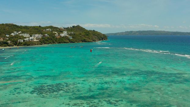 Tropical beach with turquoise water with kite-surfer rides, aerial view. Kitesurfing on a tropical island. Boracay, Philippines