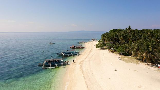 Beautiful beach. View of nice tropical beach with palms around. Holiday and vacation concept. Tropical beach. Digyo Island, Philippines.