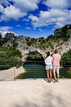 couple men and woman visiting The famous natural bridge of Pont d'Arc in Ardeche department in France Ardeche. Europe Rhone Alpes