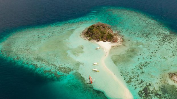aerial seascape tropical island and sand beach, turquoise water and coral reef. malacory island, Philippines, Palawan. tourist boats on coast tropical island.