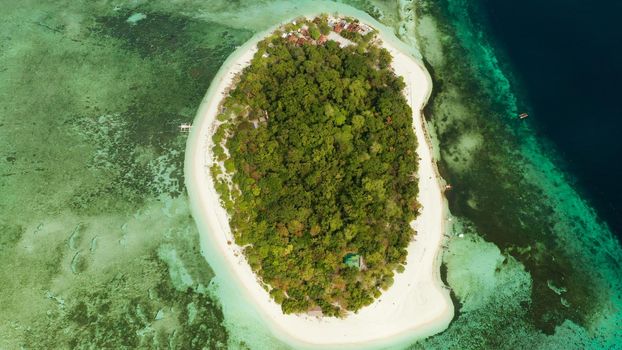 Tropical island Mantigue and sandy beach surrounded by atoll coral reef and blue sea, aerial view. Small island with sandy beach. Summer and travel vacation concept, Camiguin Philippines Mindanao