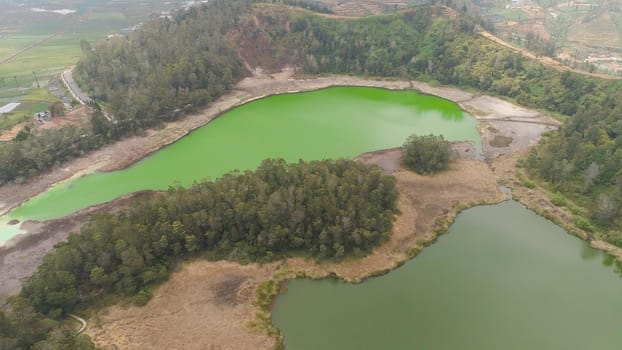 volcanic sulfur lake telaga warna in dieng plateau, java Indonesia. mountain tropical landscape lake with green water among mountains. this lake is one mainstay tourist destinations in Wonosobo Regency