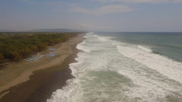 aerial view sandy beach near ocean with big waves at sunset time in tropical resort, Yogyakarta, Indonesia. seascape, ocean and beautiful beach. Travel concept. Indonesia, java
