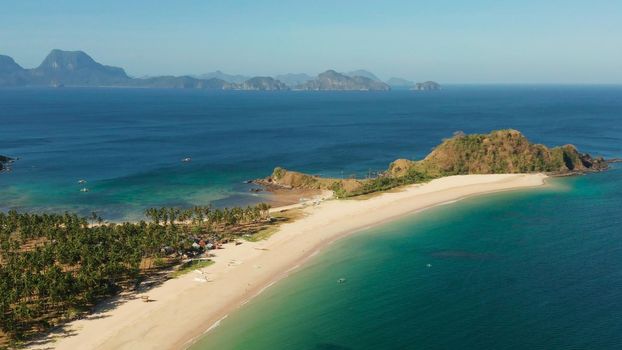 Blue sea and tropical beach, aerial drone. Nacpan, El Nido, Palawan, Philippine Islands. Seascape with tropical beach and islands. Summer and travel vacation concept