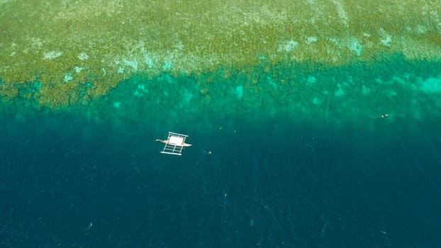 Dive boats waiting for divers on the coral reef from above, Moalboal, Philippines. Summer and travel vacation concept.