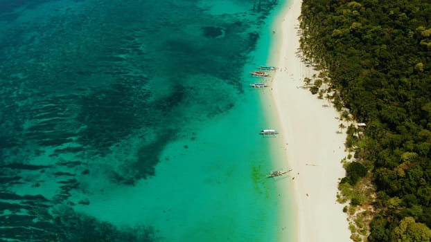 Coast with sandy beach with tourists and clear blue sea top view, Puka shell beach. Boracay, Philippines. Seascape with beach on tropical island. Summer and travel vacation concept.