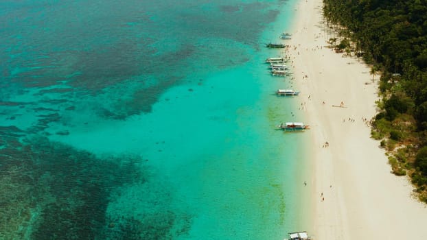 Travel concept: sand beach with tourists and turquoise water on Boracay, Philippines, aerial drone. Seascape with Puka shell beach on tropical island. Summer and travel vacation concept.