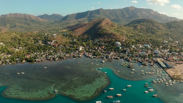 sea port, pier, cityscape Coron town with boats on Busuanga island, Philippines, Palawan. Coron city with slums and poor district. Seascape with mountains.