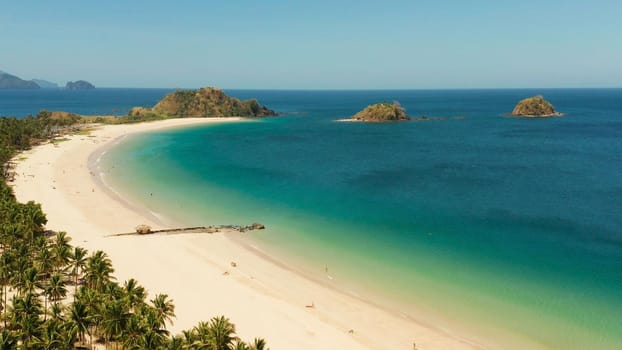 Blue sea and tropical beach, aerial drone. Nacpan, El Nido, Palawan, Philippine Islands. Seascape with tropical beach and islands. Summer and travel vacation concept