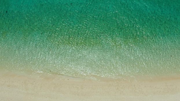 Tropical sandy beach with wave and turquoise water,copy space for text, aerial view. Ocean with waves and tropical beach. Summer and travel vacation concept