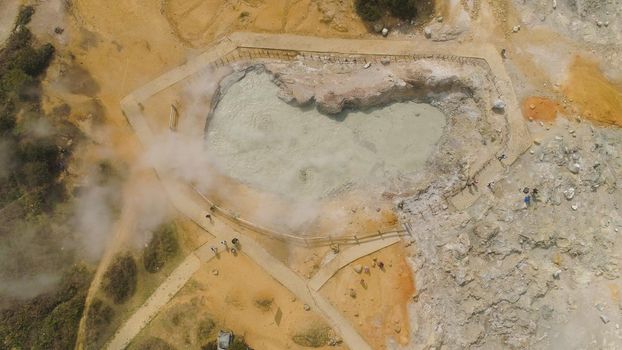 plateau with volcanic activity, mud volcano Kawah Sikidang, geothermal activity and geysers. aerial view volcanic landscape Dieng Plateau, Indonesia. Famous tourist destination of Sikidang Crater it still generates thick sulfur fumes.