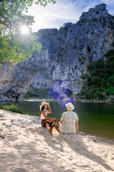 couple men and woman visiting The famous natural bridge of Pont d'Arc in Ardeche department in France Ardeche. Europe Rhone Alpes