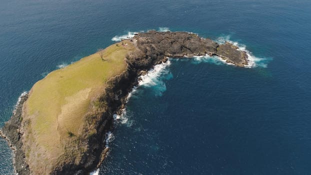 Lonely rocky island in the sea. Aerial view Uninhabited tropical island among the ocean. Travel concept.