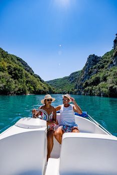 cliffy rocks of Verdon Gorge at lake of Sainte Croix, Provence, France, Provence Alpes Cote d Azur, blue green lake with boats in France Provence. Europe couple men woman mid age on vacation Provence 