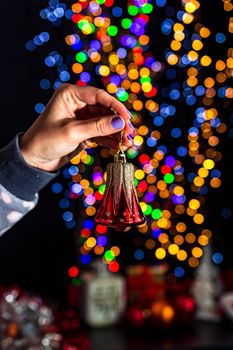 Holding Christmas decoration isolated on background with blurred lights. December season, Christmas composition.