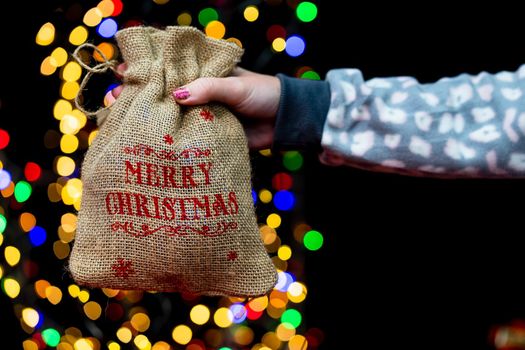 Woman's hands hold christmas decoration. Christmas and New Year holidays background, winter season with Christmas ornaments and blurred lights